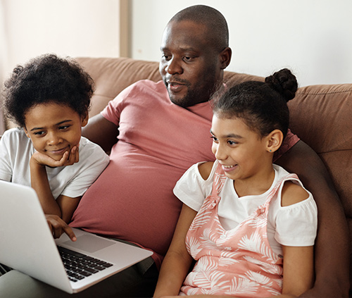 Students and their father with a laptop